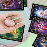 Hand holding crystals over tarot cards