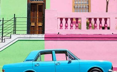 blue car against a green and pink wall