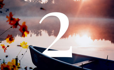 Life Path number 2 in numerology is represented by a boat on a lake at sunset.