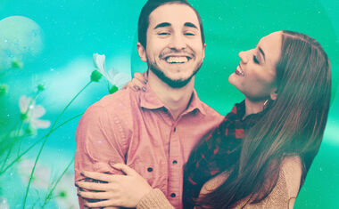 A couple smiles together against a green background for the 2023 Aquarius love horoscope.