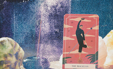 The Magician card sits on an altar with crystals and incense in the background.
