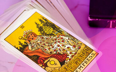 A Tarot deck sits on a table, with The Empress on top.