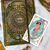 The World card from the Modern Witch Tarot sits on top of a book with a drawing of an eye.