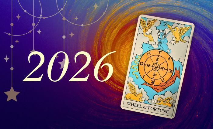 The Tarot card of 2026, the Wheel of Fortune, hovers against a swirling background and stars.
