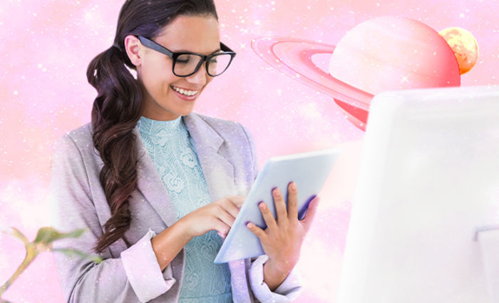 A woman works with a tablet against a pink planetary background.