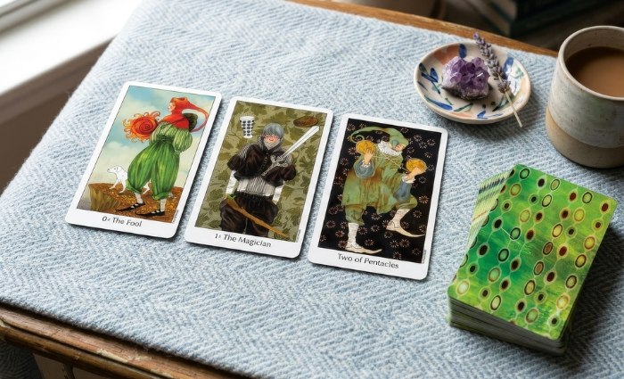 The Dreaming Way Tarot deck by Rome Choi and Kwon Shina, displaying a three-card reading. Based on psychological research, the cards feature characters with neutral expressions from dream states, using a vintage children's book palette, bold checkerboards, and contemporary fashion elements for dream analysis and clearing emotional baggage.