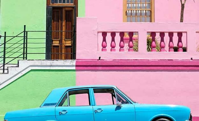 blue car against a green and pink wall