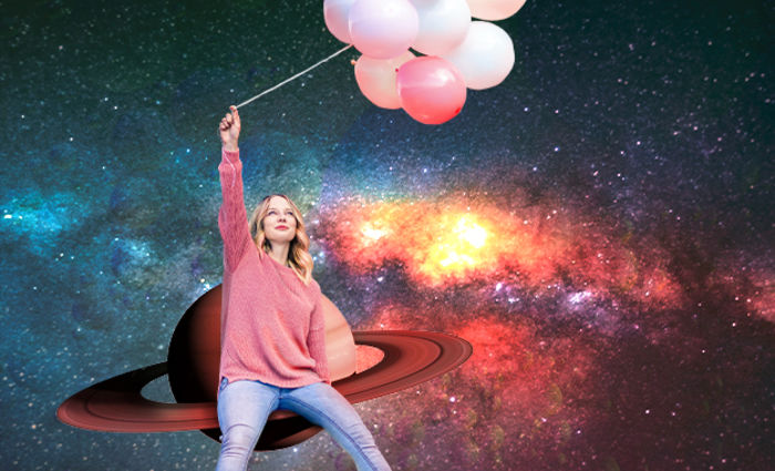 woman holding balloons in front of saturn