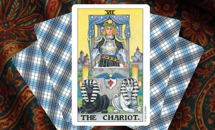 A classic Chariot card rests on a floral tapestry.