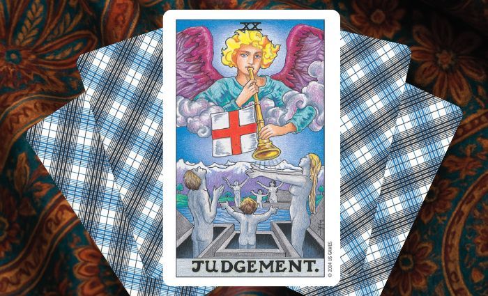 A classic Judgement card rests on a floral tapestry.